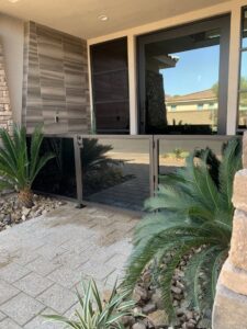 A modern black metal and glass fence barrier installed at a house entrance by Custom Customs Inc. in Henderson, NV.