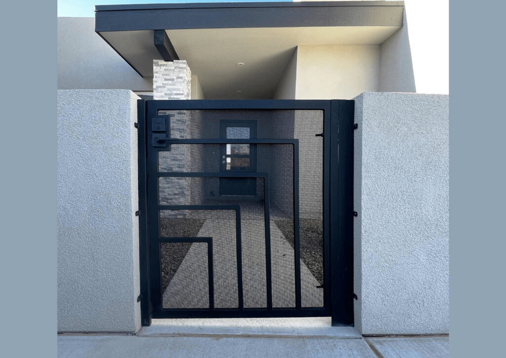 A modern black metal pedestrian gate with a geometric design, installed by City Iron LLC in Albuquerque, NM.