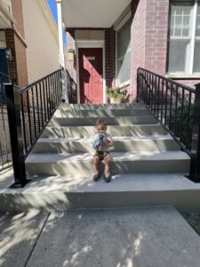 Modern black metal stair railings installed on outdoor concrete steps by Ironcraft Welding in Chicago, IL.