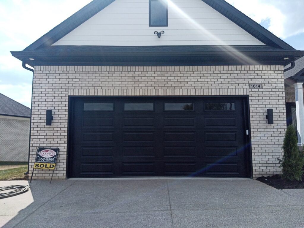 A modern black residential garage door installed on a new home by Honest Overhead Garage Doors in Elizabethtown, KY.