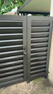 A modern black slatted pedestrian gate installed by Osuna Ornamental Fences & Gates in Cutler Bay, FL.