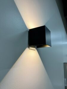 Modern black wall sconce providing ambient lighting, installed by Innovative Electric in Wichita, KS.