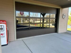 A modern brown garage door with multiple glass panels, showcasing a stylish installation by Overhead Doors Unlimited, LLC in Appleton, WI.