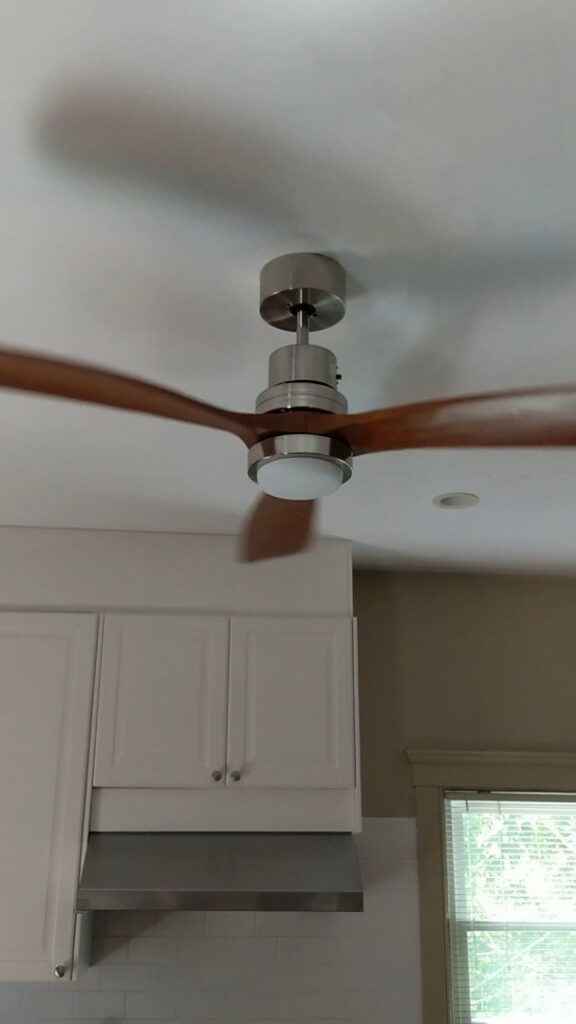 A modern ceiling fan with wooden blades professionally installed in a kitchen by Colman Electric in Cambridge, MA.