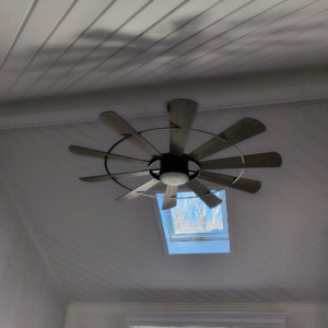 A modern ceiling fan with a light installed on an angled ceiling by Eastern Electrical Contractors in Waterbury, CT.
