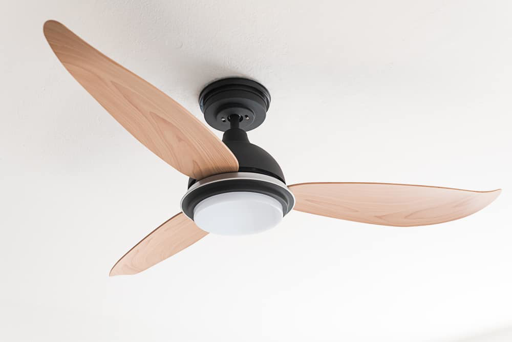 A modern ceiling fan with wooden blades and a light kit installed by Jack-O-Lantern Electric in Knoxville, TN.