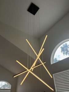Modern linear chandelier installed in a high ceiling by Turn It On Electric in Phoenix, AZ