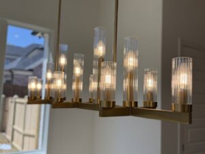 A modern chandelier with multiple illuminated bulbs, showcasing a lighting installation by Precision Electric and Lighting Services in Olive Branch, MS.