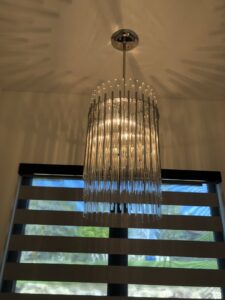 A stylish modern cylindrical chandelier installed, demonstrating lighting fixture expertise from Veritas Electric in Yalaha, FL.
