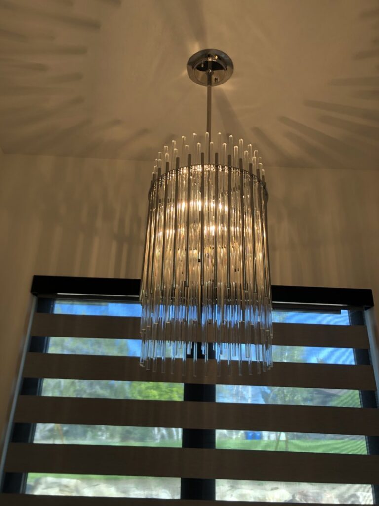 A stylish modern cylindrical chandelier installed, demonstrating lighting fixture expertise from Veritas Electric in Yalaha, FL.