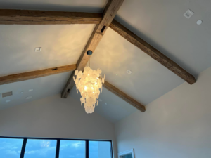 A modern chandelier and recessed lighting installed on a vaulted ceiling by Focal Electric Company in Dallas, TX.