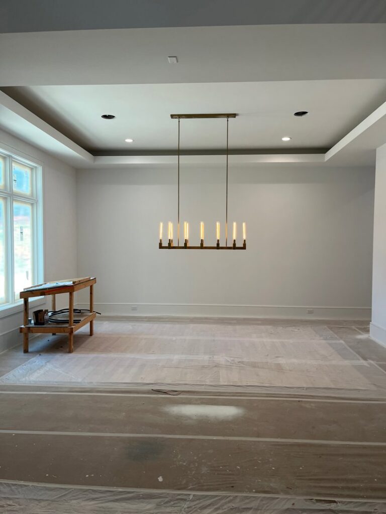 A modern linear chandelier and recessed lighting installed in a new room by E-Systems Electrical Inc. in Cumming, GA.