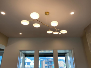 A modern chandelier and recessed lighting installed in a ceiling by Electric Avenue in Lincoln, NE.