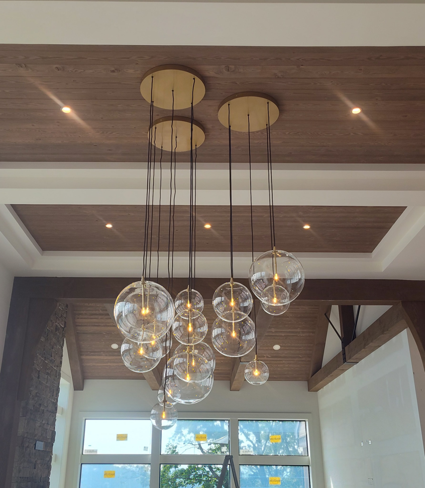 A modern multi-globe chandelier and recessed lighting installed in a wooden ceiling by Ryco Electric in York, PA