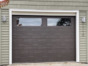 A modern dark brown garage door with two horizontal windows, installed by Max Garage Door in Minneapolis, MN.