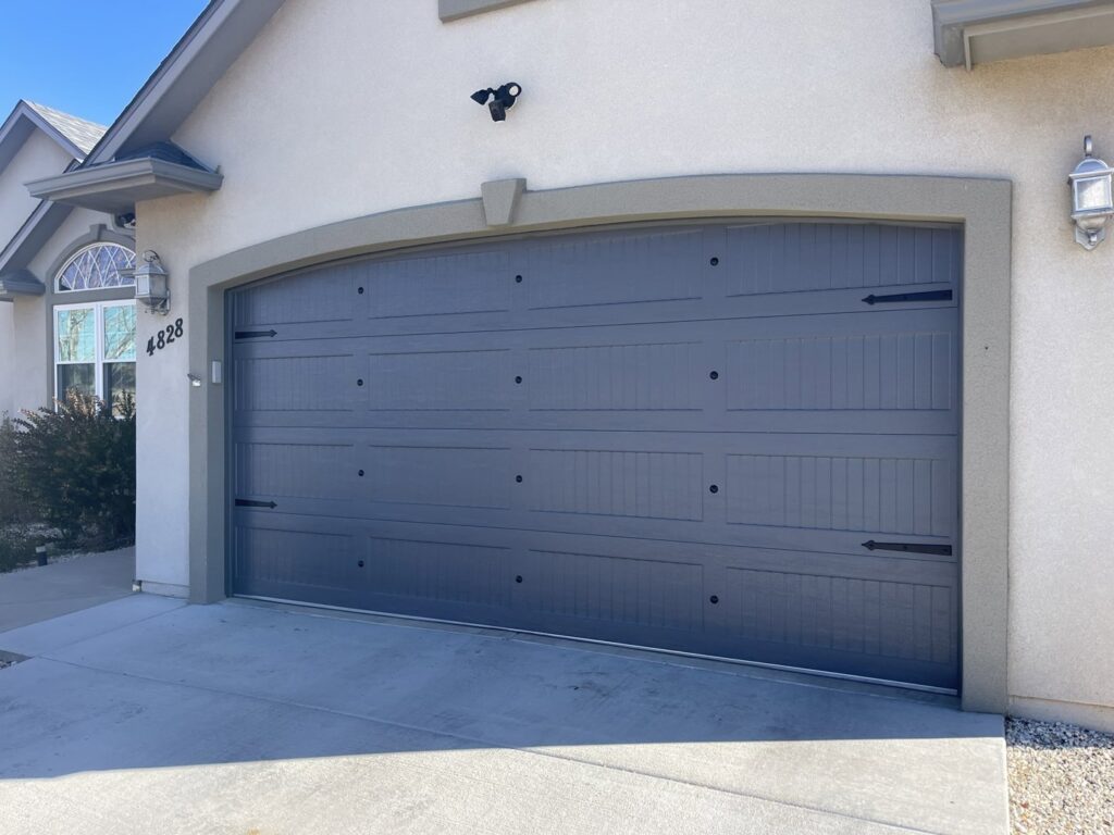 A modern dark gray garage door with decorative hardware on a residential home by Prutch's Garage Door in Colorado Springs, CO