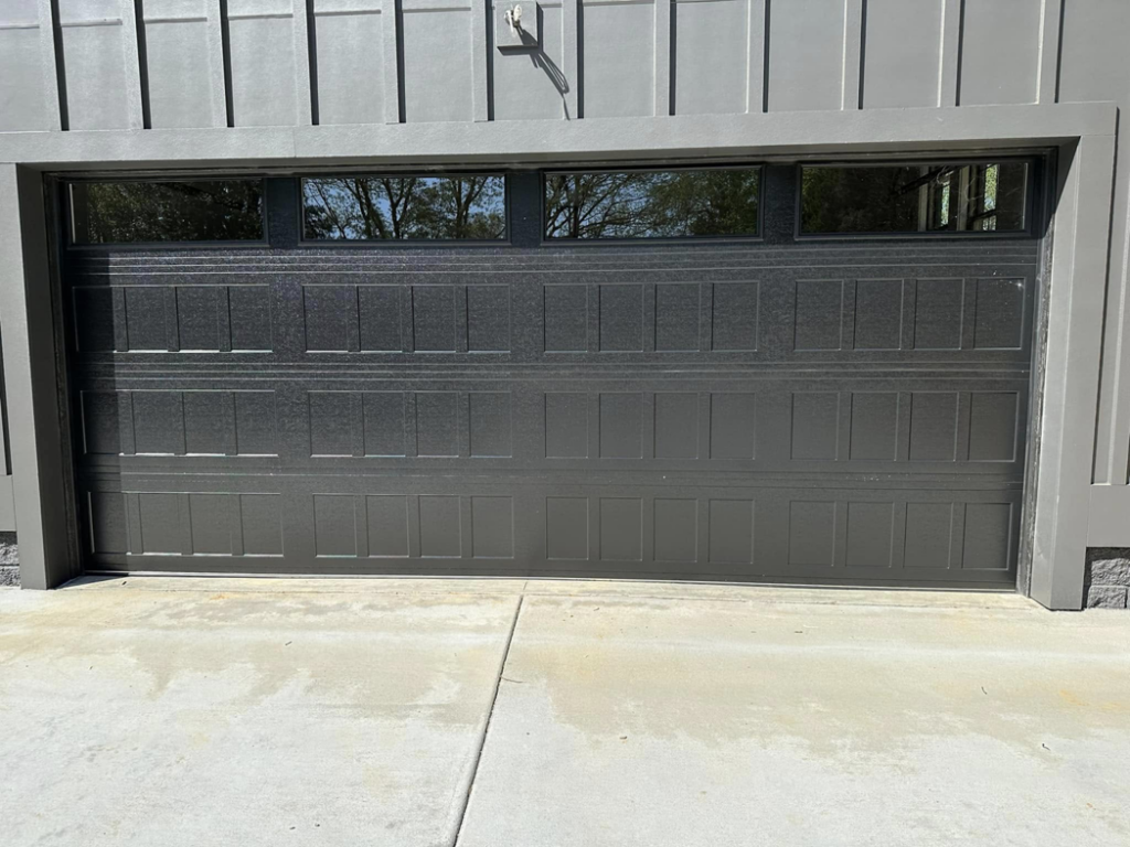 A modern dark grey garage door with top windows installed on a home by Up Garage Door in Nashville, TN.