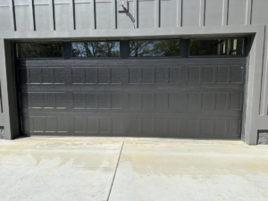 A modern dark grey garage door with top windows installed on a home by Up Garage Door in Nashville, TN.