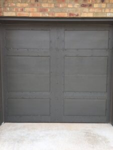 A modern dark grey garage door installed by Windsor Door, Siding & Window in Oklahoma City, OK.