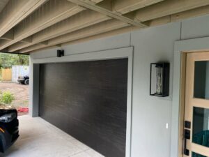 A modern dark wood-look garage door installed by On Track Garage Doors in Charleston, SC.