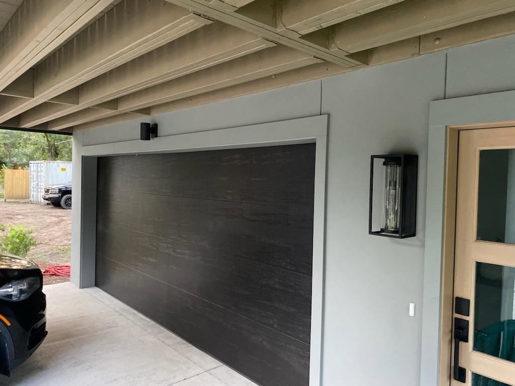 A modern dark wood-look garage door installed by On Track Garage Doors in Charleston, SC.
