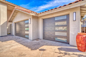 Two modern dark wood-look garage doors with frosted windows installed by Blue Fox Garage Doors in Gilbert, AZ.