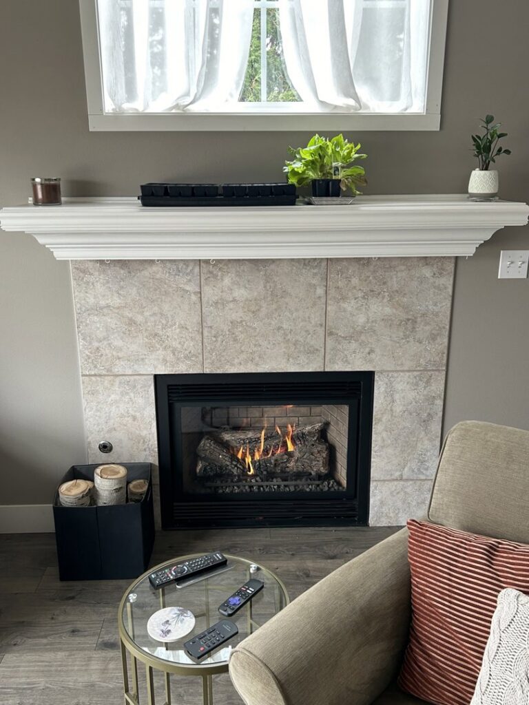 A modern fireplace with a gas insert and decorative logs, installed by Spartan Heating, Cooling and Fireplaces in Cedar Rapids, IA
