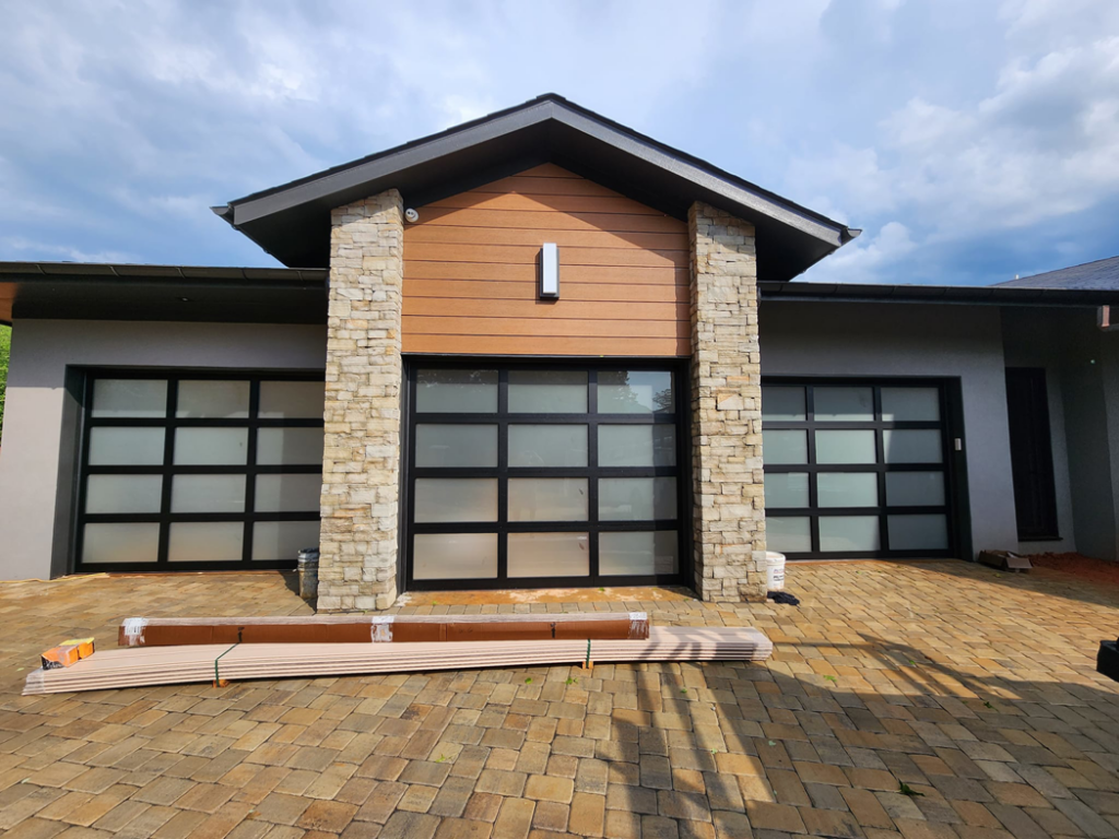 Three modern frosted glass garage doors installed on a new construction home by Getsinger's Overhead Doors in Spartanburg, SC.