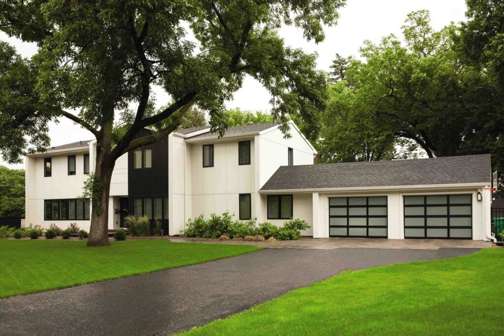 Modern frosted glass garage doors installed on a white and black home by Overhead Door Company of Salem in Salem, OR.