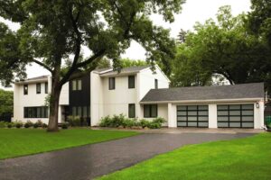 Modern frosted glass garage doors installed on a white and black home by Overhead Door Company of Salem in Salem, OR.