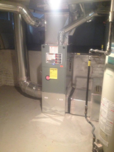 A modern furnace unit with extensive ductwork installed in a basement by Geddes Heating and Cooling in Aurora, CO.
