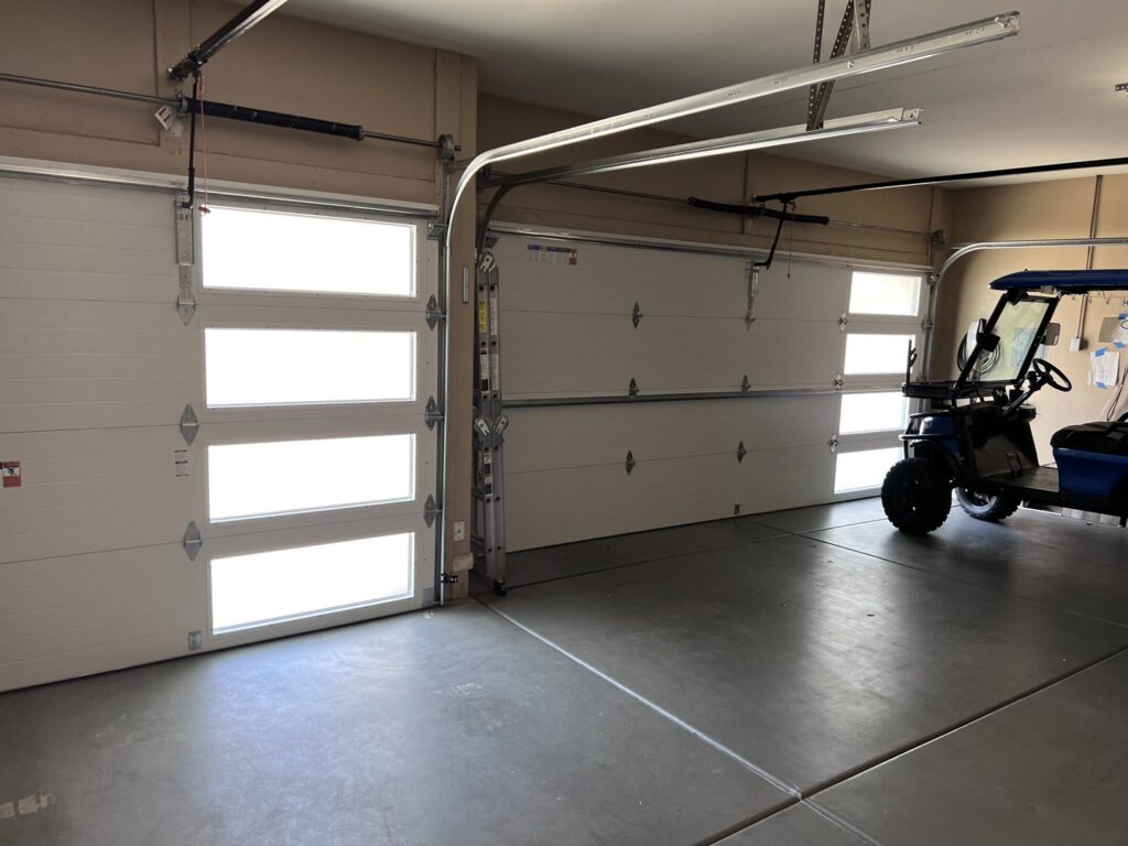 Interior view of a garage with newly installed modern garage doors by Iconic Garage Door Service in Queen Creek, AZ.