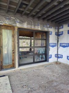 A modern glass garage door installation in progress on a new build, handled by JT's Overhead Doors in Gilbert, AZ.