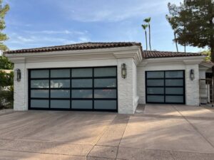 Two modern glass garage doors installed on a white stucco home by Morning Star Garage Doors in Phoenix, AZ