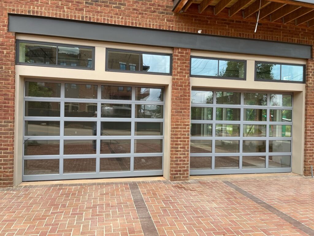 Modern glass garage doors installed on a commercial building by Precision Door Service of Huntsville, AL.