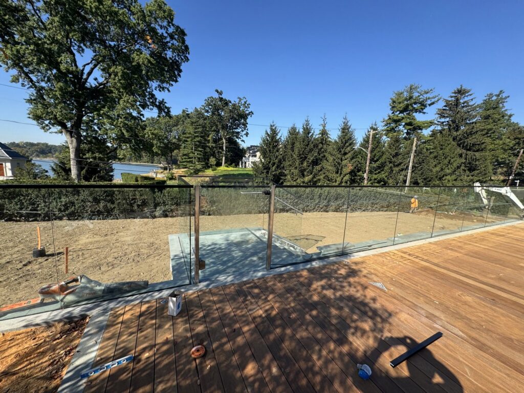 A modern glass panel fence installed around a deck by RP Fencing & Gates in Brewster, NY