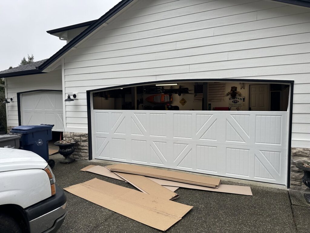 Two modern glass panel garage doors installed on a residential building by CHS Garage Repair of Seattle, WA.