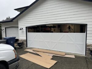 Two modern glass panel garage doors installed on a residential building by CHS Garage Repair of Seattle, WA.
