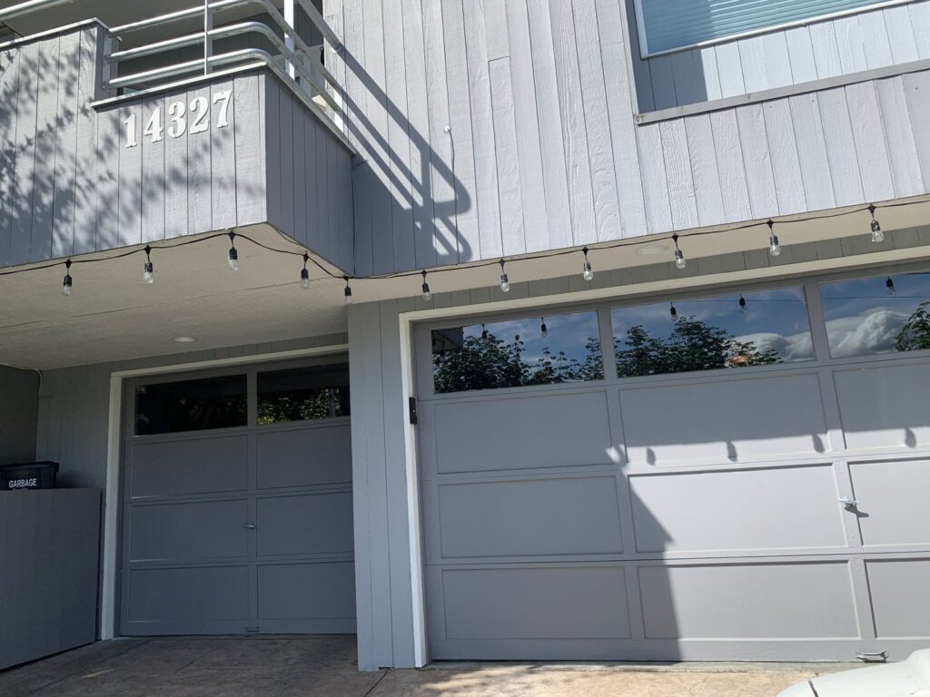 A modern glass panel garage door installed on a residential home by CHS Garage Repair of Seattle, WA.