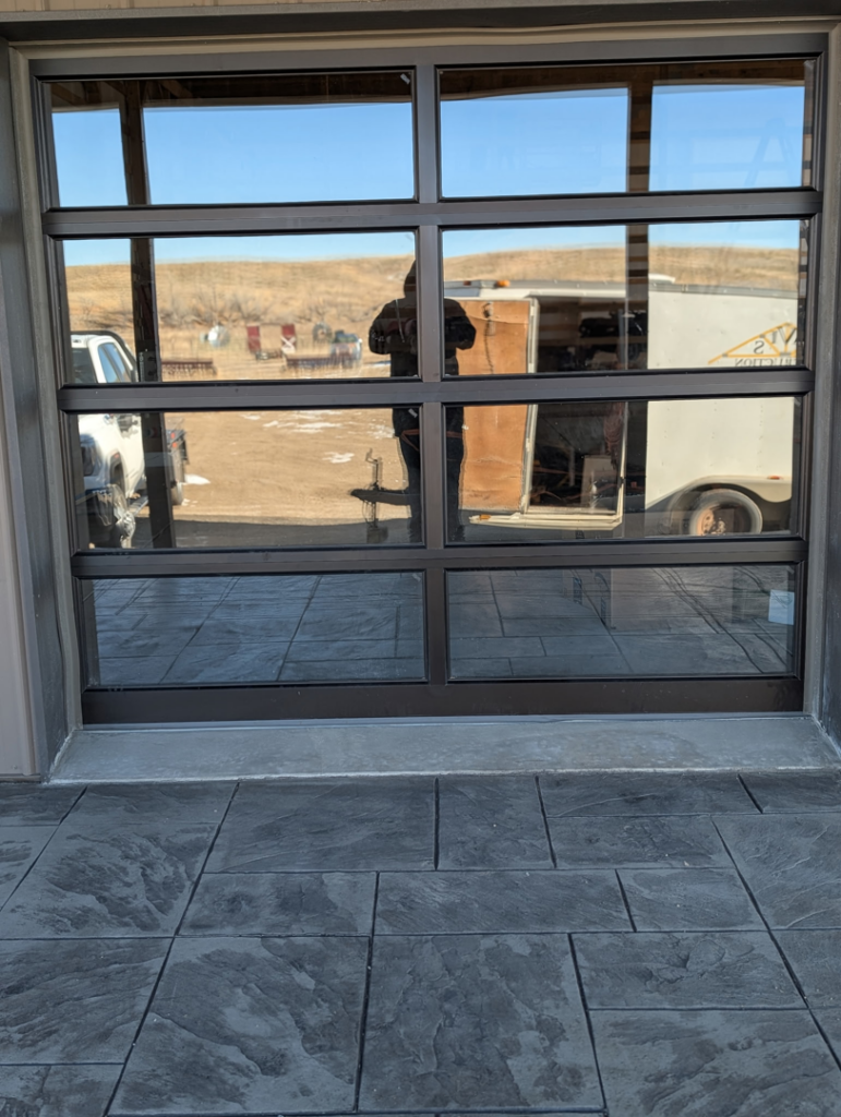 A modern glass panel garage door installed by Usa Garage Door Services and Construction, LLC at 1206 E 6th St, USA.