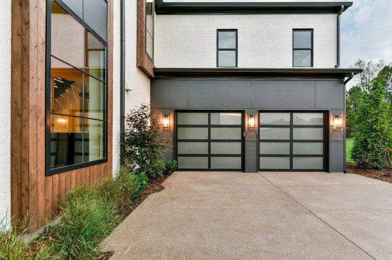 Two modern glass panel garage doors installed on a contemporary home by Access Garage Doors-Chattanooga, TN