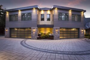 Two modern glass panel garage doors on a contemporary home, showcasing work by Babcock Garage Doors in Vancouver, WA
