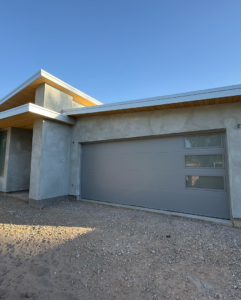 Modern gray garage door with windows on a new home by Mr. Garage Door in Bell Gardens, CA.