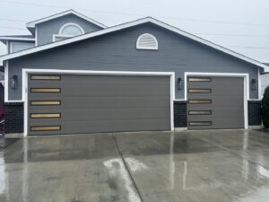 Two modern gray garage doors with horizontal windows installed by Discount Garage Door Company in Spokane, WA.