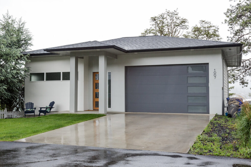 Modern grey garage door with horizontal windows on a contemporary home, installed by Continental Door Company, Spokane Valley, WA.