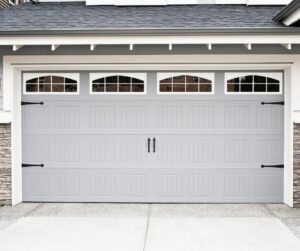 A modern grey garage door with decorative hardware, expertly installed by SS Garage Door Repair in Denver, CO.