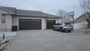 A modern grey garage door with horizontal windows installed on a residential home by Prutch's Garage Door in Page, AZ