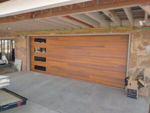 A modern horizontal panel wooden garage door with windows installed by Colorado Garage Door Pro's in Denver, CO