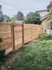 A modern horizontal slat wooden fence installed in a residential backyard by Sparta Fencing in Ely, UK.