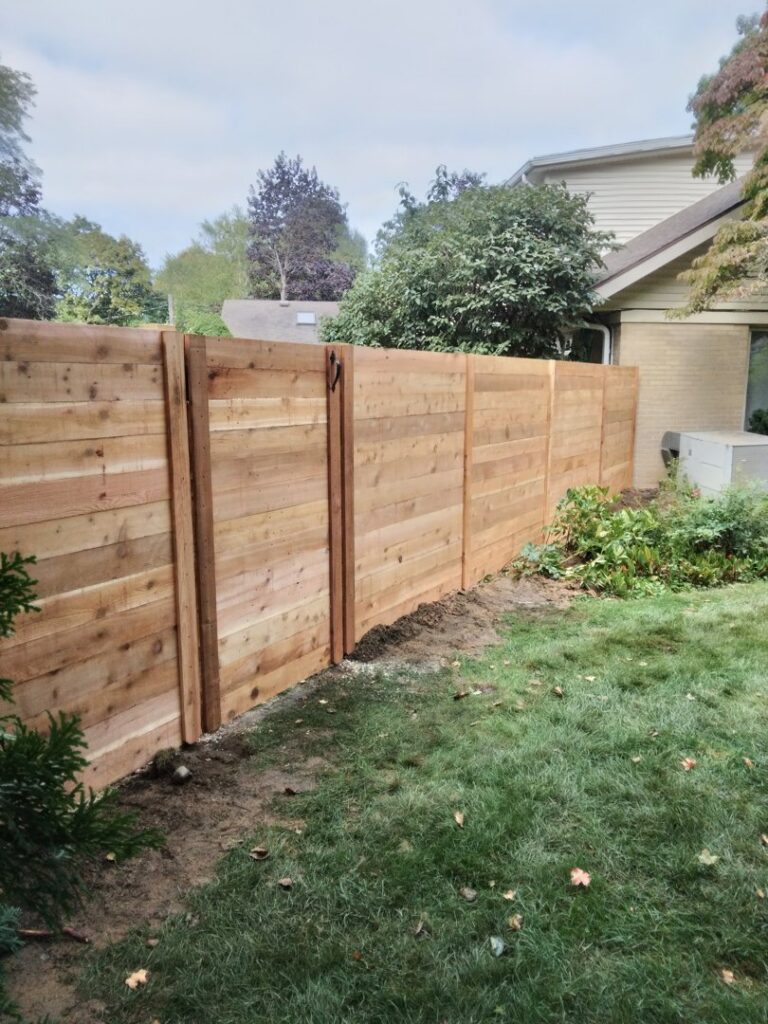 A modern horizontal slat wooden fence installed in a residential backyard by Sparta Fencing in Ely, UK.